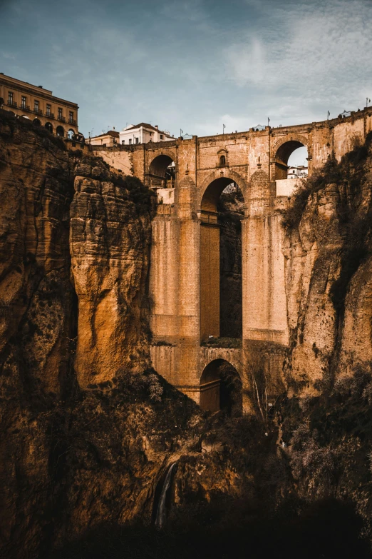 a bridge over a mountain side with a train going by