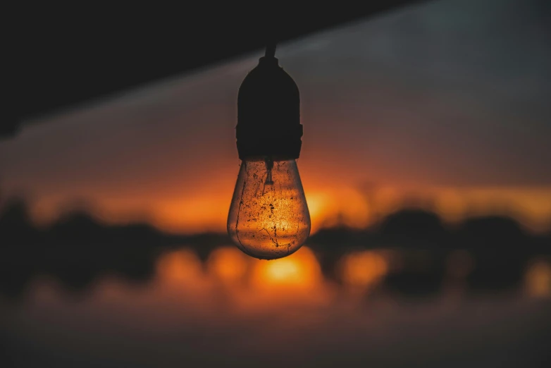 an upside down light bulb sitting under the darkness