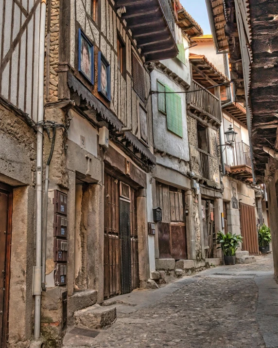 a narrow cobble stone road near some buildings