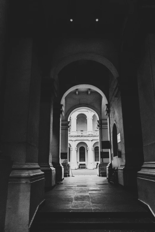 an old po of a person walking up a hallway in the middle of a building