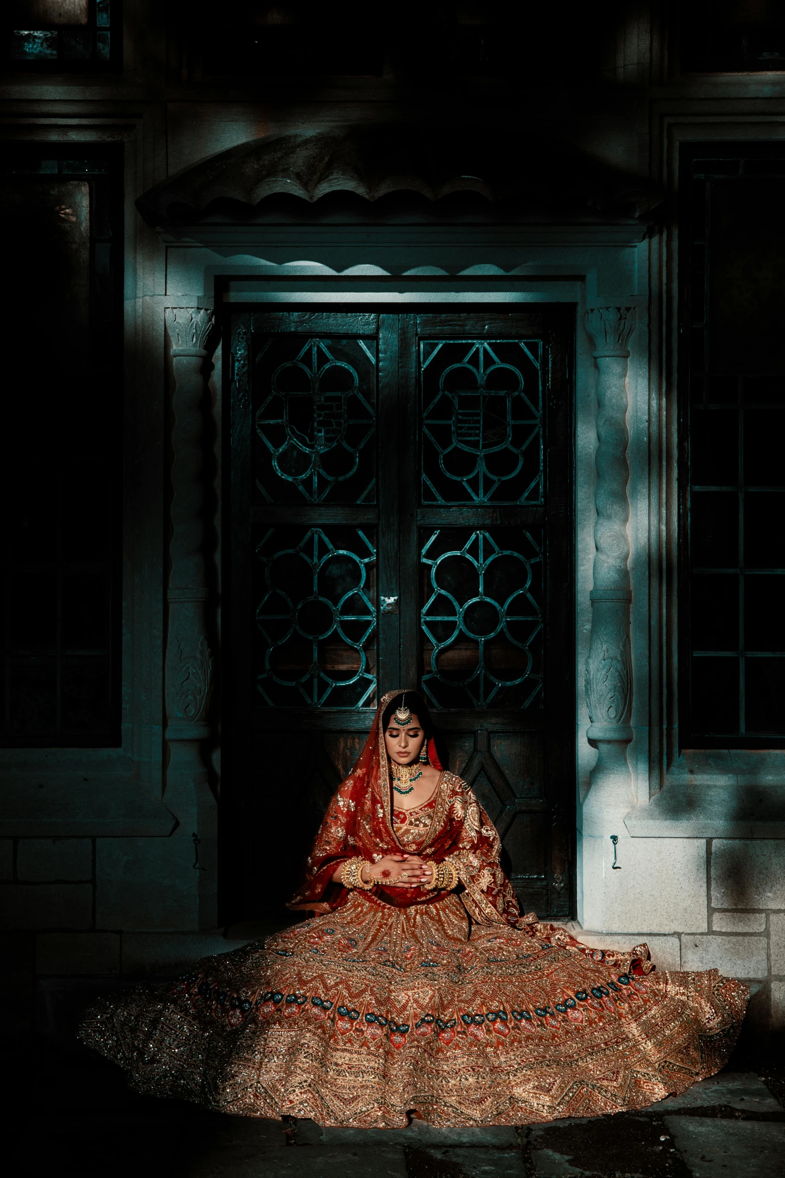 a woman dressed in a wedding dress sits on the doorstep