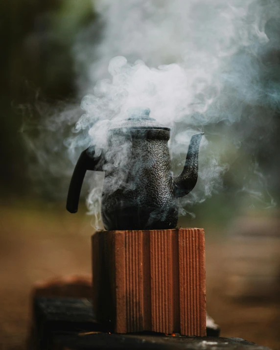 smoke coming from a black teapot shaped as a structure