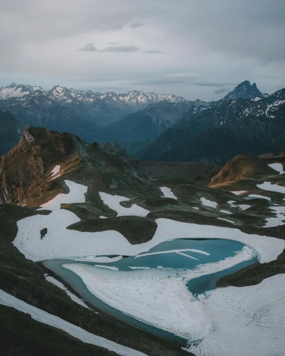 a frozen lake surrounded by snowy mountain tops