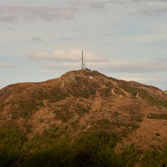 a mountain has a telephone tower on top of it