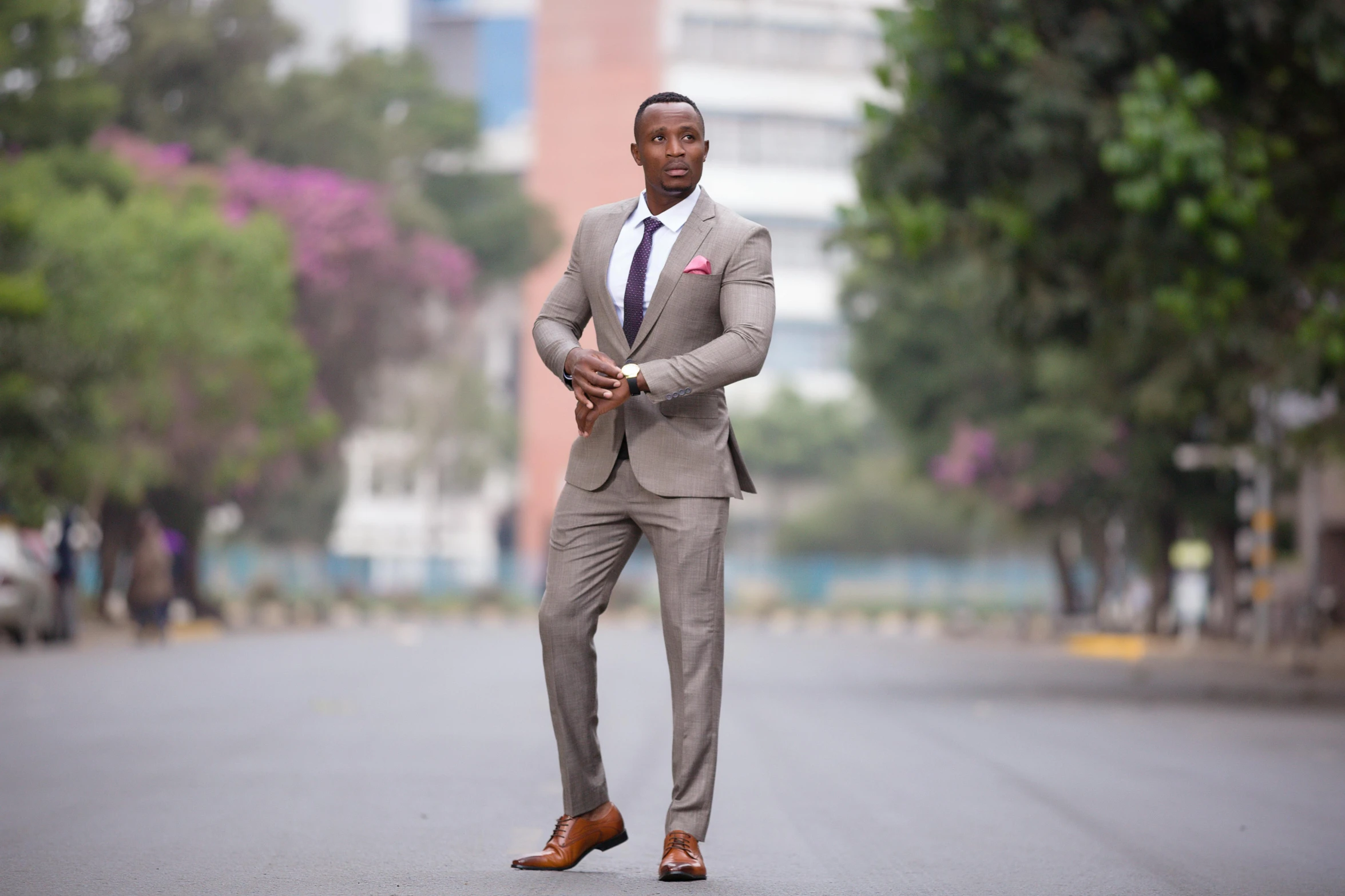 man in a suit crossing the street and posing