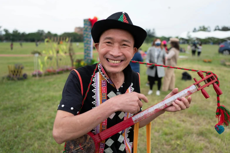 man in black hat holding up an item from the ground