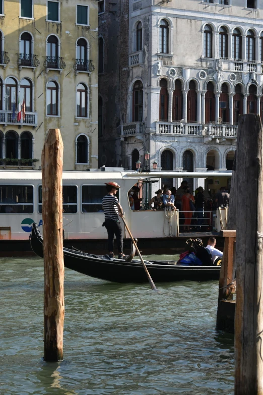 a gondola boat filled with people near large buildings