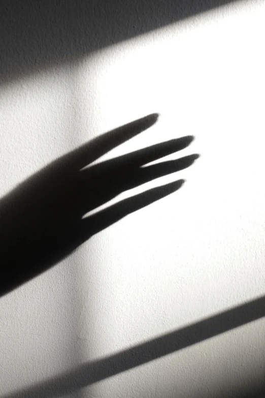 there is the shadow of someone's hand on a wall