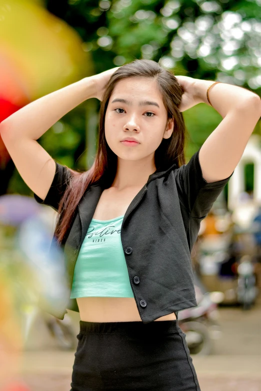 a young asian woman standing in front of a rainbow ball