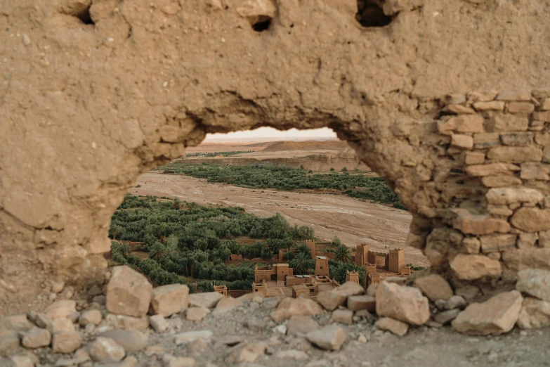 an image of the mountains and land through a hole