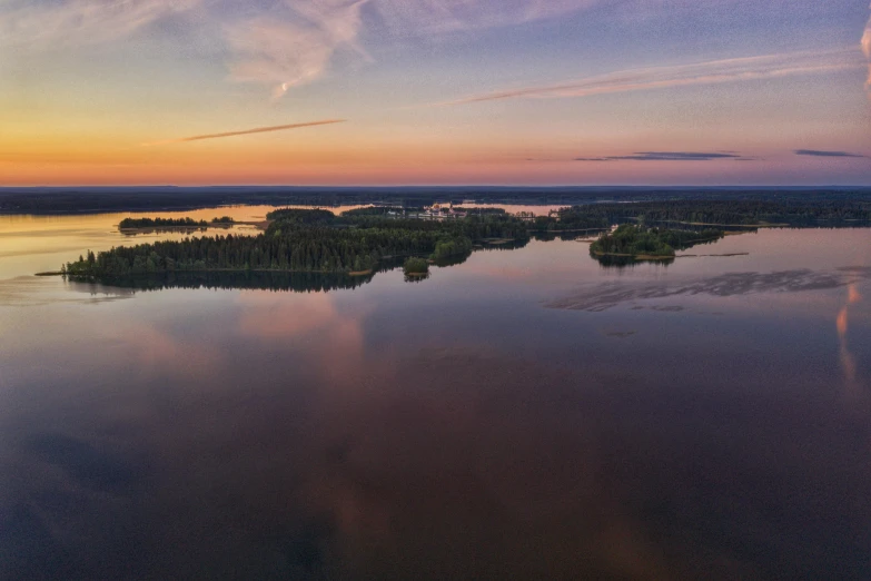 aerial view of land and water with trees on the shore