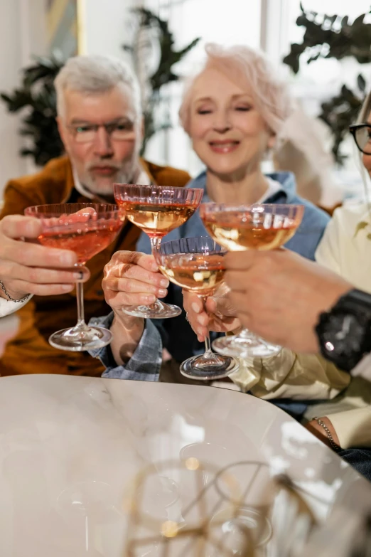 three people with their hands together in wine glasses