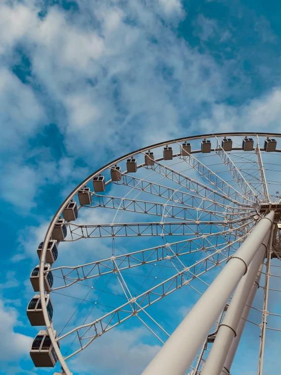 a tall ferris wheel with blue skies in the background