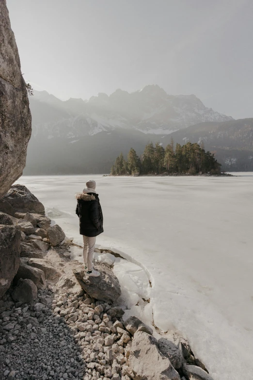 a person standing by the edge of a large rock