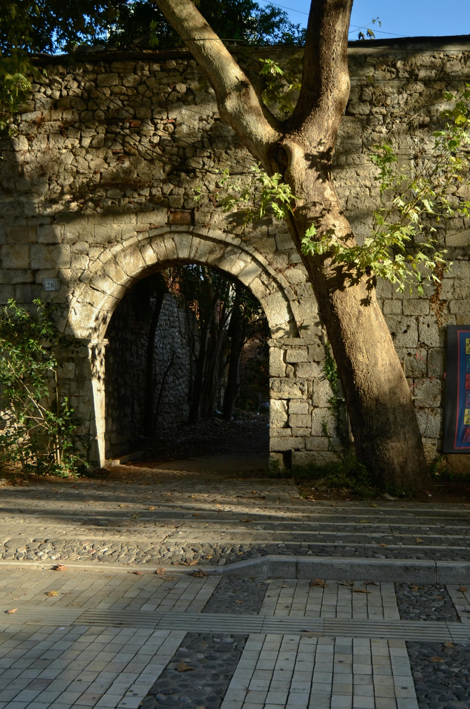 a walkway and archway on an outside with trees