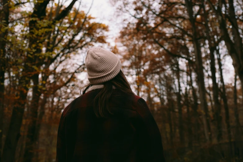 the woman is walking along in the woods