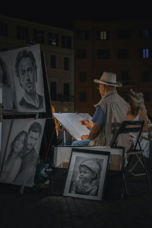 a man is sitting with art work on his side at night