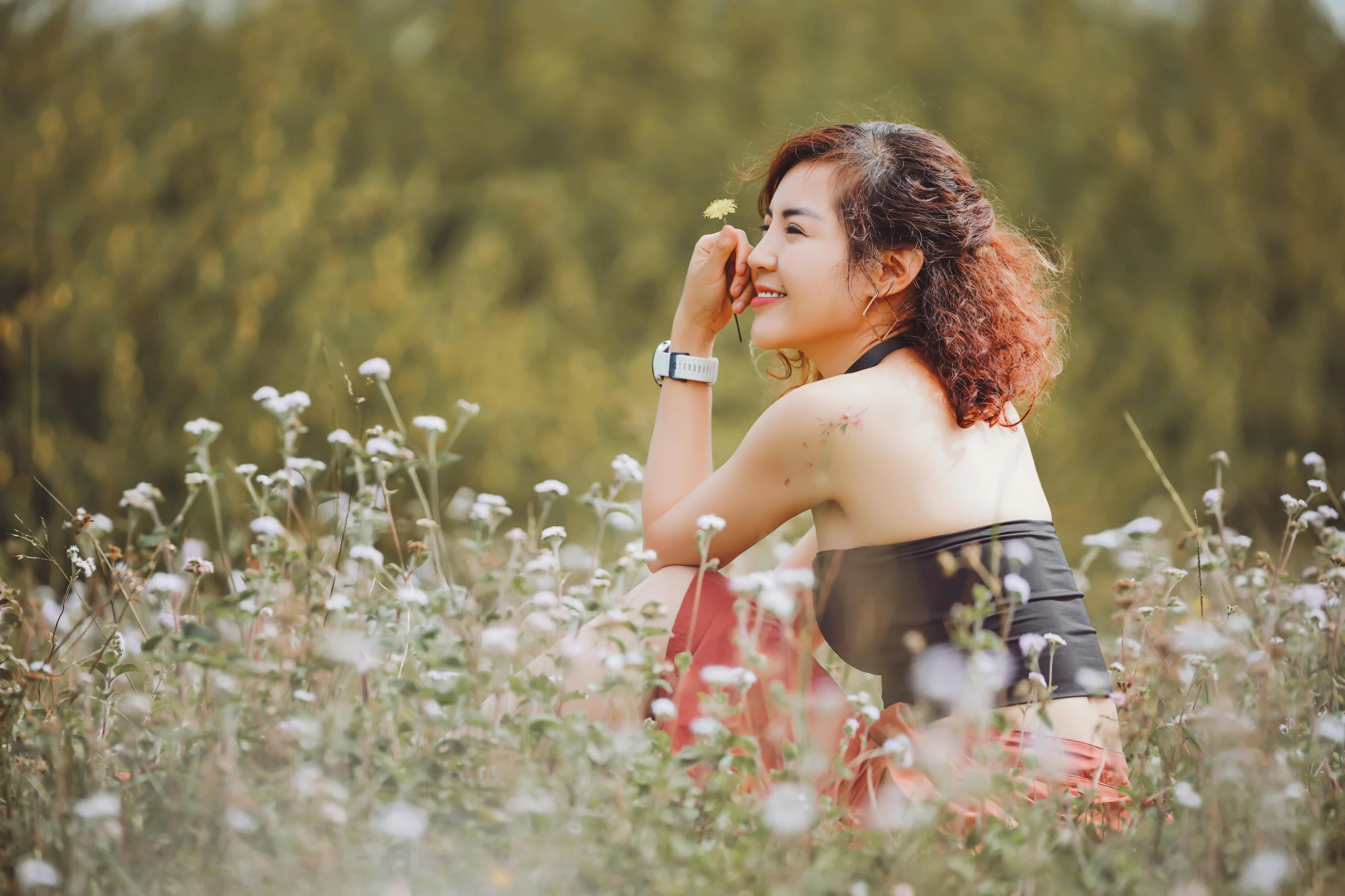 a woman kneeling on top of a field holding an object