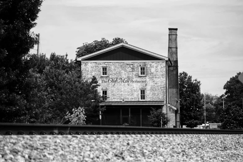 old brick building surrounded by trees in a rural area