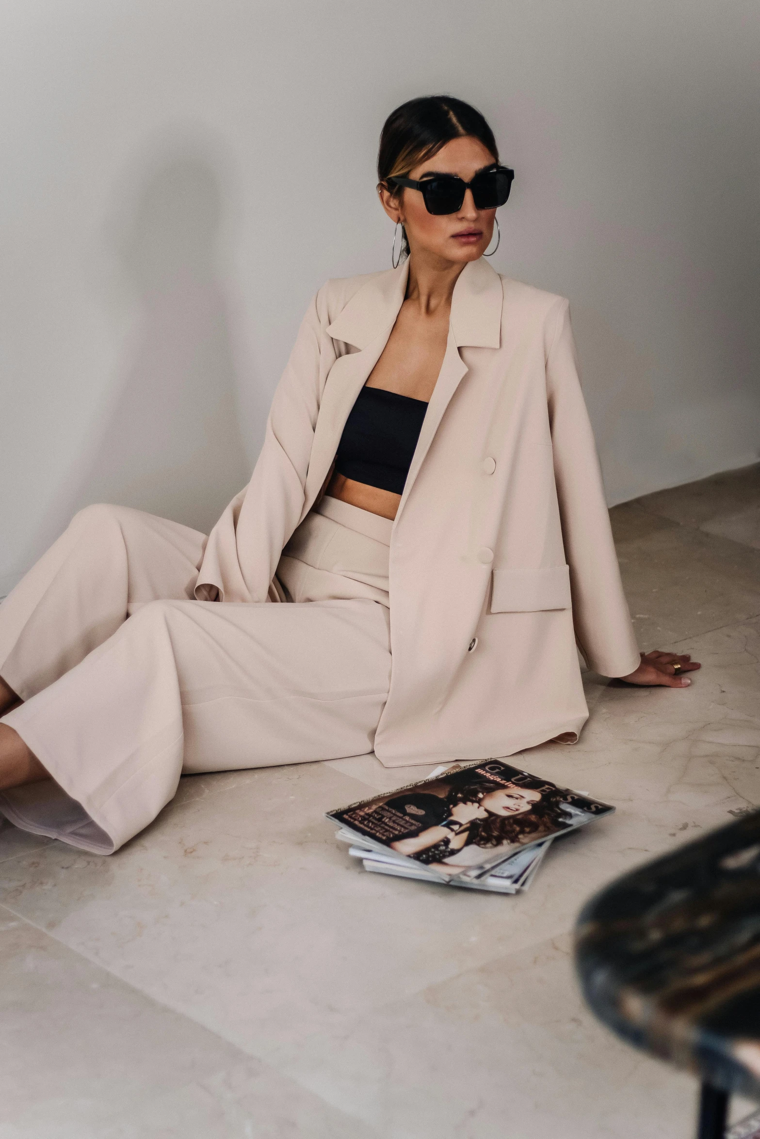 a woman is sitting on the ground wearing a suit