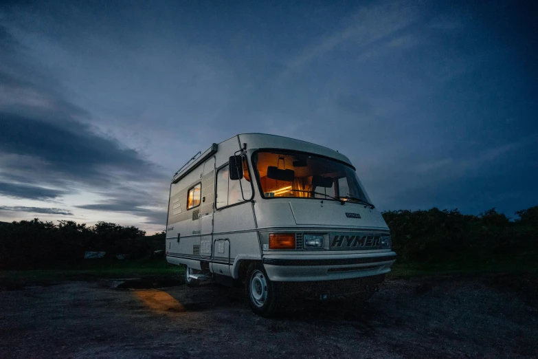 a white bus parked in the middle of the night