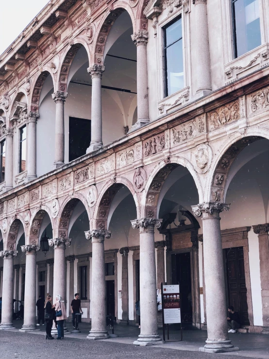 several columns and arches are in front of two large buildings