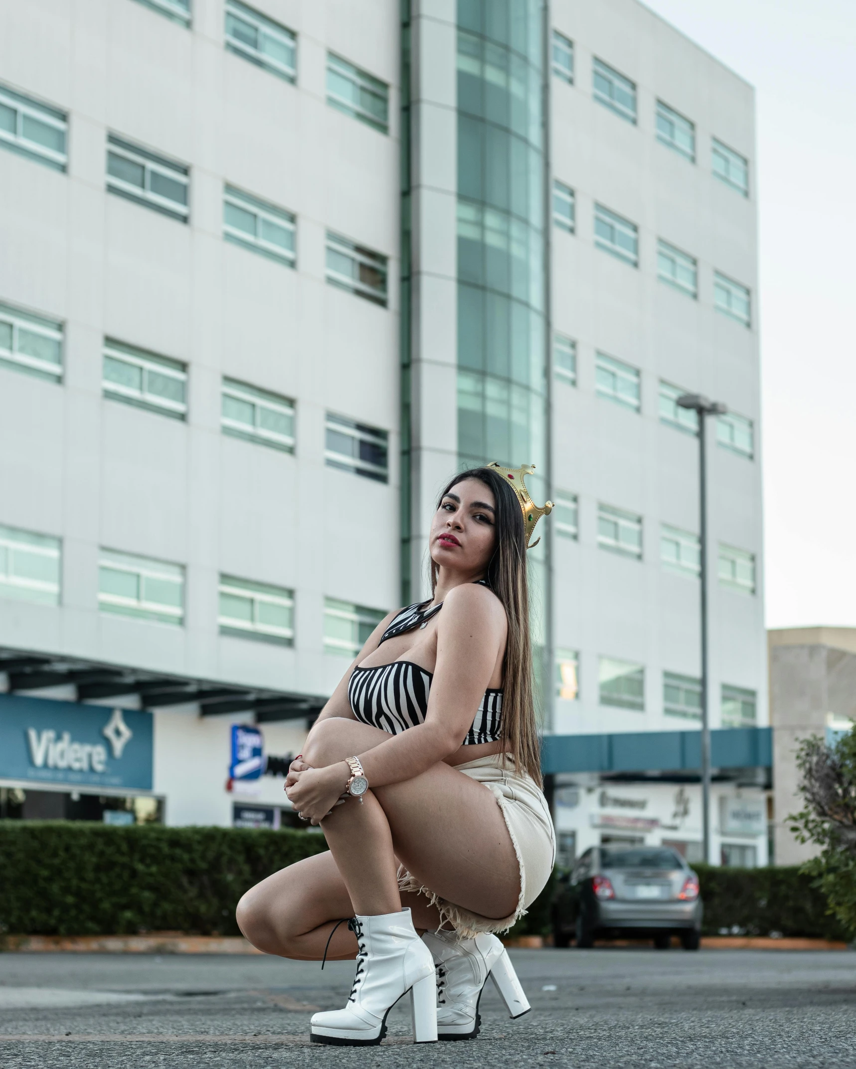 a woman squatting down on the ground with white boots