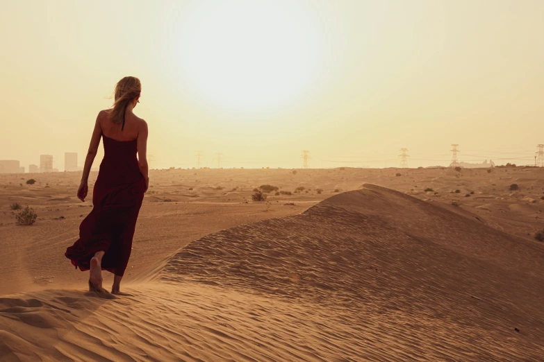 a person walking in sand dunes on a  day