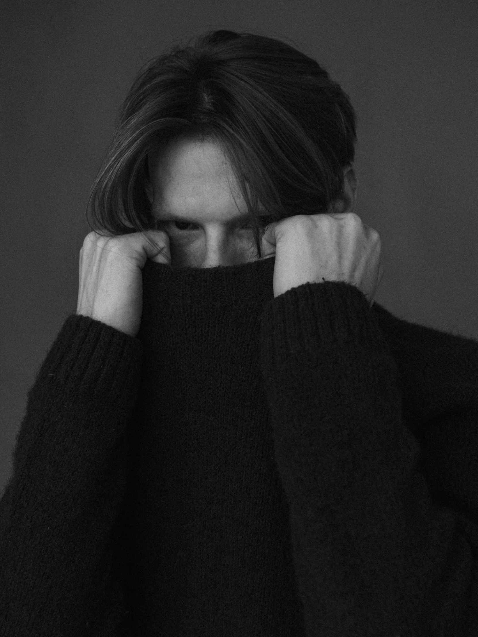 a woman covering her face in black and white