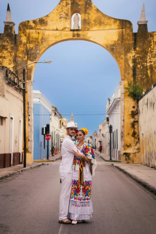 two people dressed in mexican attire are walking down an urban street