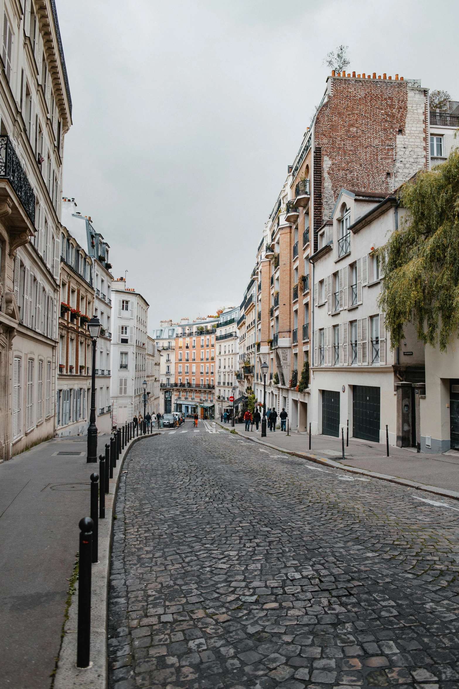 people walking on the sidewalk between two buildings