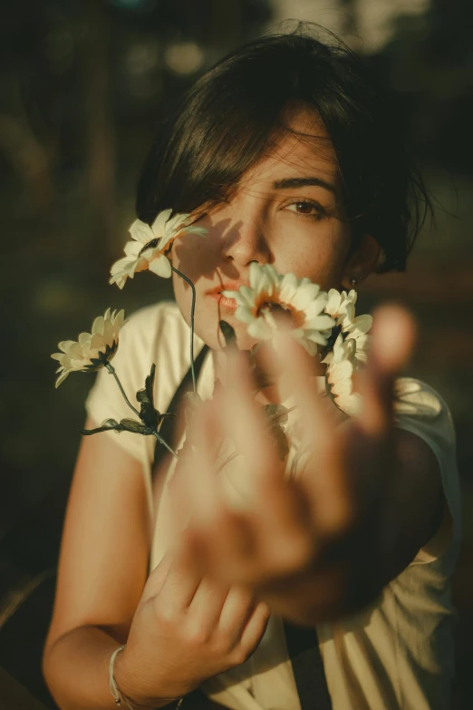 a woman holding a flower to her face