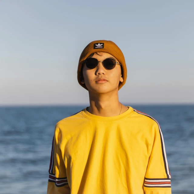 a young man wearing sunglasses and a knit hat