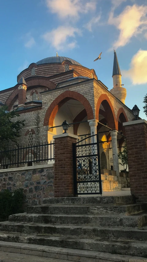 a brick building with an archway and iron railing