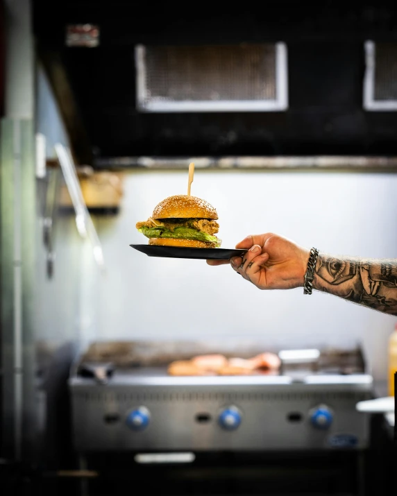 person with a plate in hand showing a hamburger on it