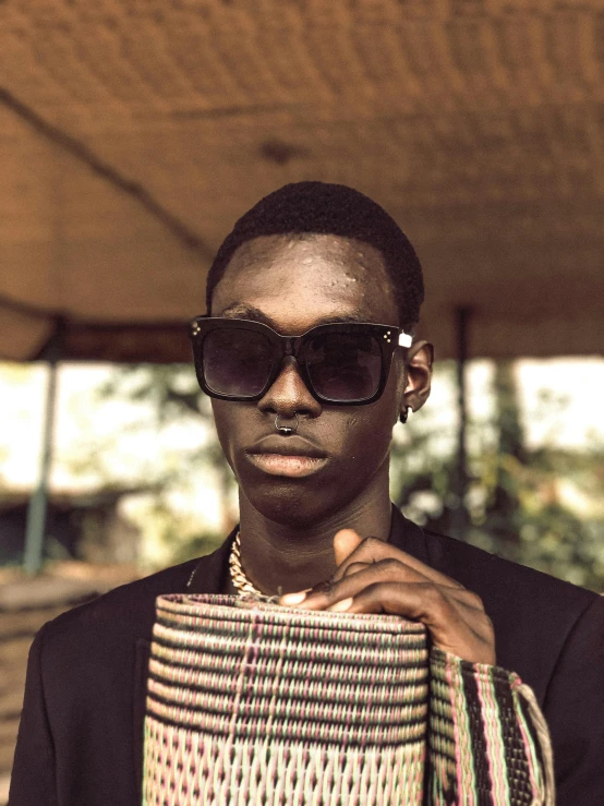 a black man with shades wearing a necktie and black sunglasses