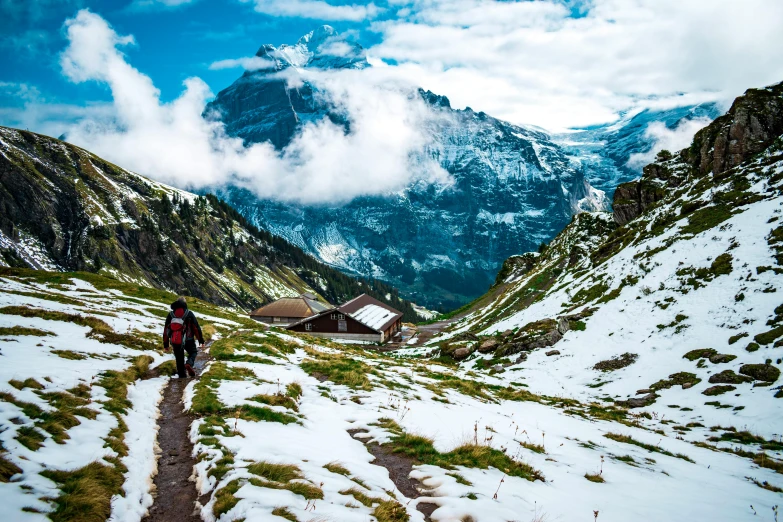 a man hiking down a trail through the mountains