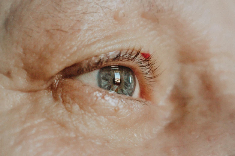 an eye is seen through the center of an old persons eye