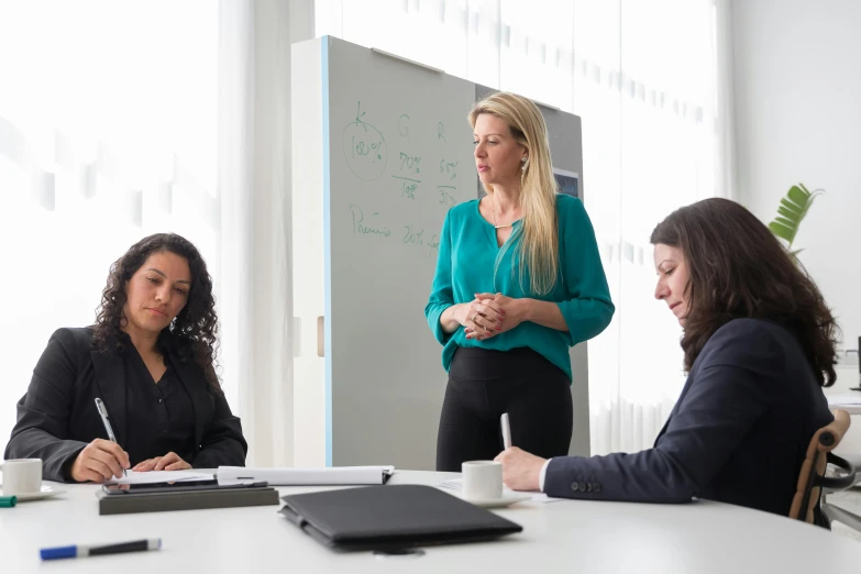 three women are sitting at a table and talking