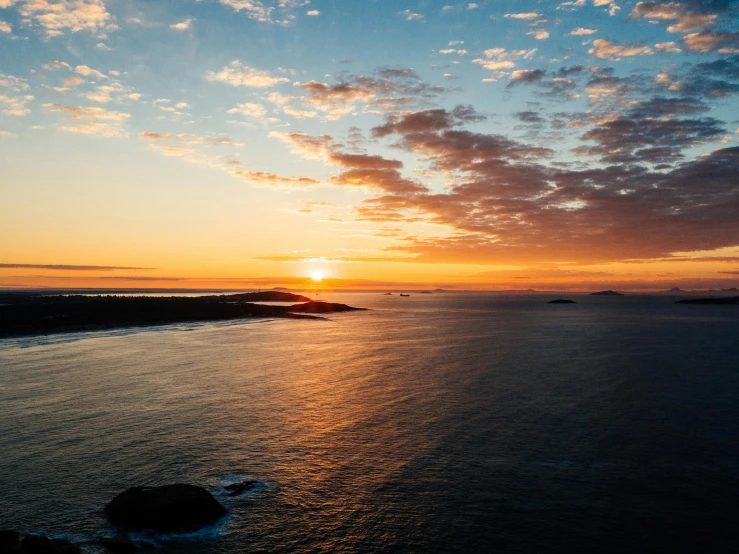 the sun is setting over a bay, on a body of water