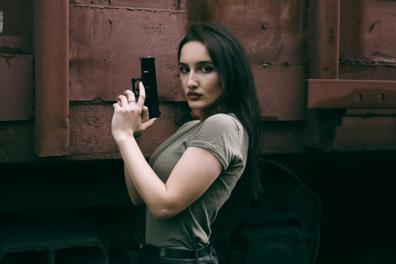 a young woman posing next to a red train holding a cellphone