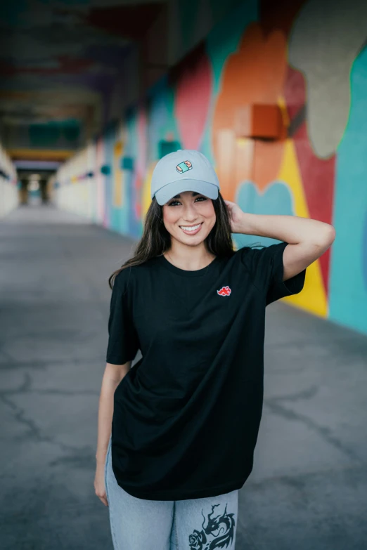 a young woman posing for the camera in front of a mural