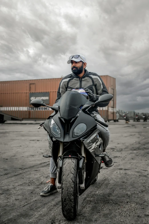 the man is riding his motorcycle on the parking lot