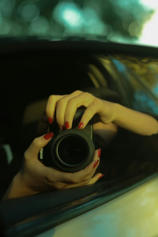 a lady taking a picture in the rear view mirror