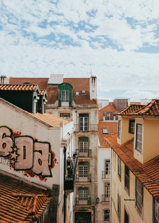 rooftops covered in graffiti under a partly cloudy sky