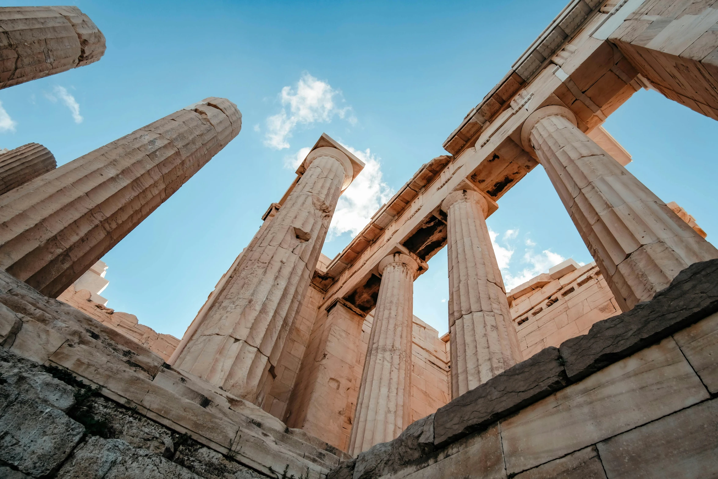 four columns stand together against a bright blue sky