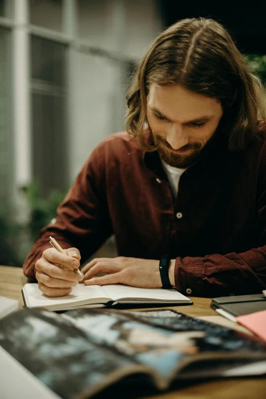 there is a man that is writing on the desk