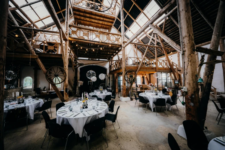 a long room filled with tables and chairs covered in white linens