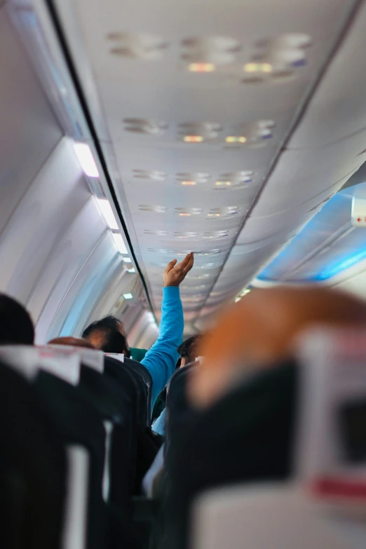 a person waving from the seat on a airplane