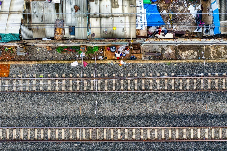 a person walking down train tracks towards a building